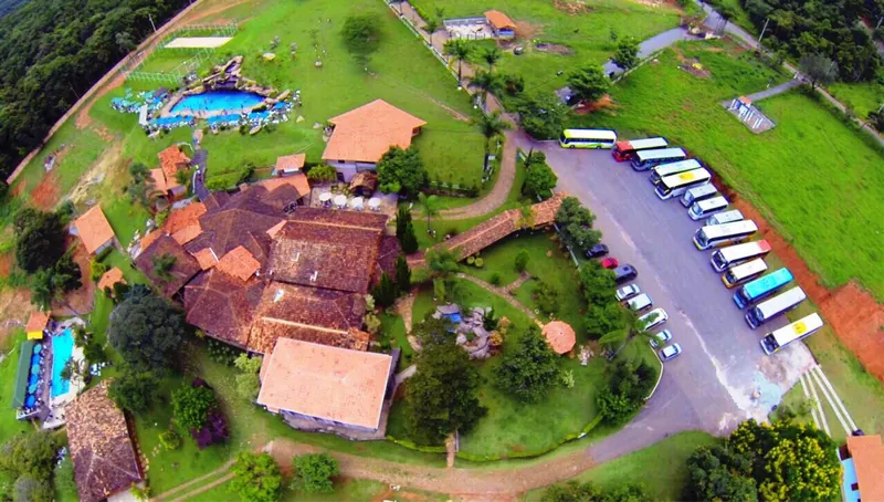 Vista aérea da fazenda com piscinas, telhados e estacionamento