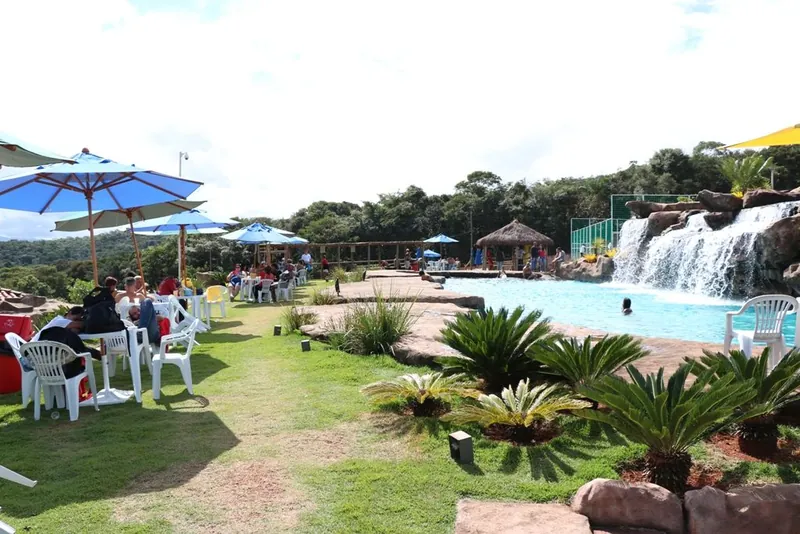 Área da piscina com guarda-sóis e cascata