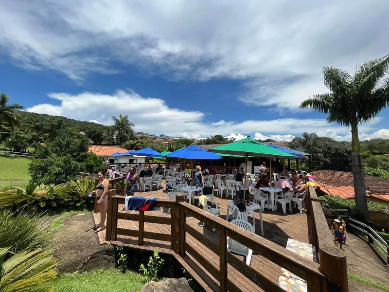 Deck de madeira com guarda-sóis ao lado da piscina