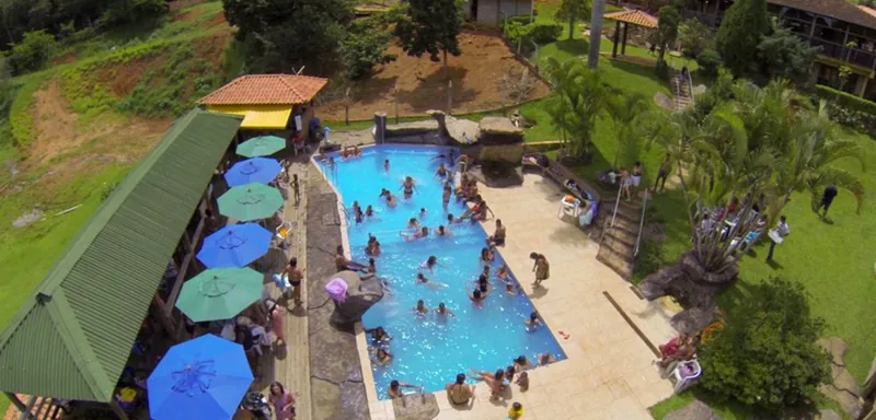 Piscina vista de cima com guarda-sóis azuis